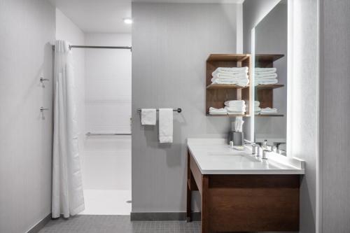 克拉尔维尔Staybridge Suites - Iowa City - Coralville, an IHG Hotel的白色的浴室设有水槽和淋浴。
