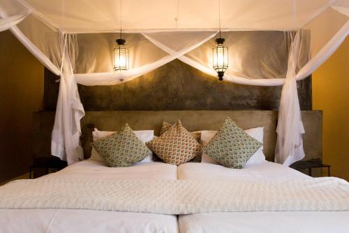 温特和克橄榄园宾馆的卧室配有带枕头的白色床
