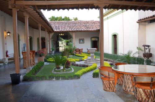 科利马拉梅赛德酒店的一个带桌椅的庭院和一个花园