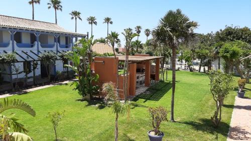 扎霍拉萨尔拉米庄园公寓酒店的一座种植了房屋和棕榈树的花园