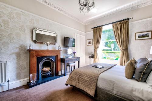爱丁堡The Hedges的一间卧室配有一张带壁炉和镜子的床