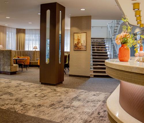 埃森Hotel Essener Hof; Sure Hotel Collection by Best Western的一个带楼梯的大堂和一间带桌子的房间