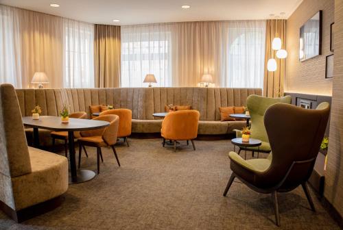埃森Hotel Essener Hof; Sure Hotel Collection by Best Western的一间设有桌椅和沙发的等候室