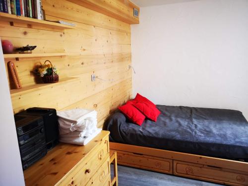 蒂涅Borsat - Beau Studio 4pax sur les pistes, avec balcon的一间卧室设有一张床和木墙