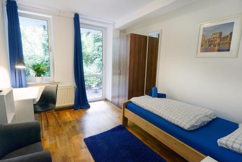 汉堡罗藤鲍姆地下室旅馆的一间卧室配有一张床、一张书桌和一个窗户。
