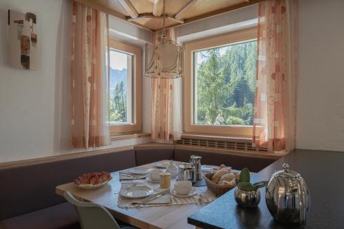 圣马蒂诺-因巴迪亚Ciasa Iachin Mountain Apartment的一间带桌子和窗户的用餐室
