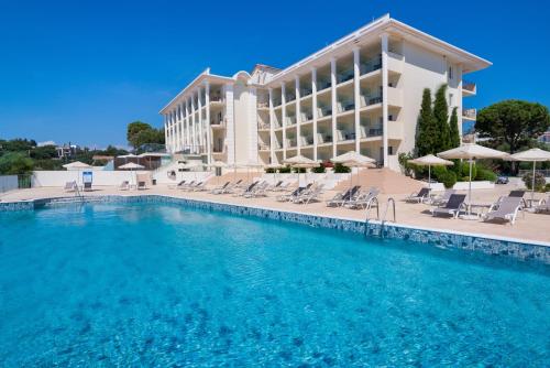 扎金索斯镇Avalon Palace Hotel - Adults Only的大型酒店,设有大型游泳池和椅子