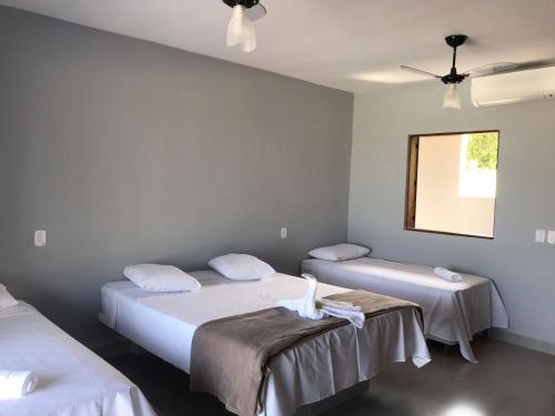 帕拉蒂Recanto Filadélfia的客房设有两张床和吊扇。