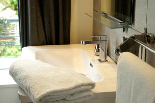 孔卡尔诺La Villa des Sables的浴室配有盥洗盆、镜子和毛巾