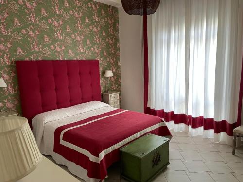 雷焦卡拉布里亚Centro Storico, Piazza Carmine: La Casa di Angela的一间卧室配有一张红色床头板的床
