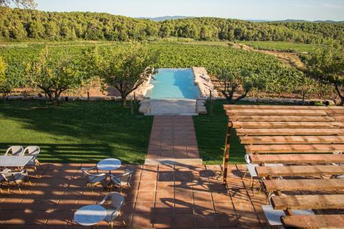 Font-RubíCasa Gran 1771 - MontRubí Winery Hotel - Adults Only的游泳池前带桌椅的天井
