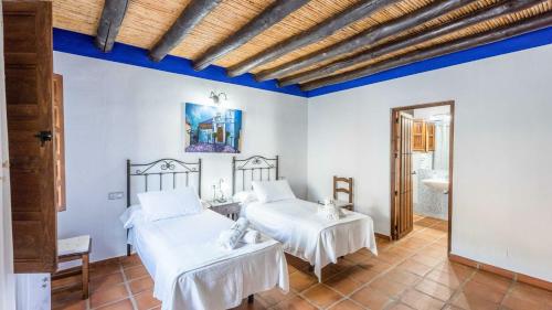 蒙达Casa Guajar 2 Monda by Ruralidays的蓝色天花板客房的两张床