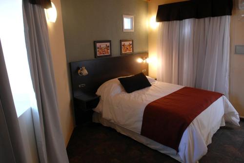 门多萨巴拉奇洛复式公寓的一间带床的卧室,位于带窗帘的房间