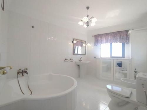 阿罗纳Tango House的白色的浴室设有浴缸和卫生间。