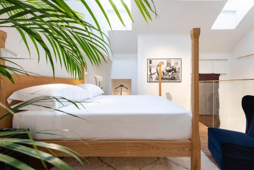 米兰Vico Milano的一间卧室配有白色床单和植物