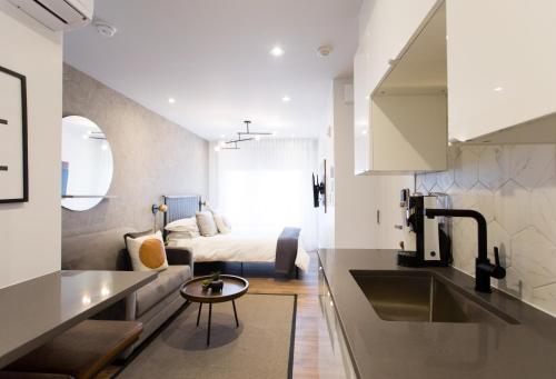 蒙特利尔Blue Oasis Studio with Full Kitchen and Bath by Den Stays的厨房和带床的客厅