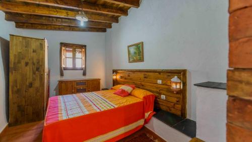 奥尔希瓦Cortijo El Chinas Orgiva by Ruralidays的一间卧室配有一张带木制床头板的床