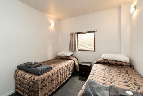 亚历山德拉Centennial Court Hotel的小房间设有两张床和窗户