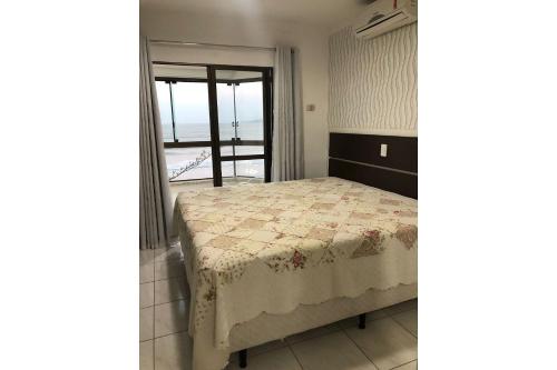 伊塔佩马Apartamento Frente Mar Meia Praia的一间卧室配有一张床,享有海景