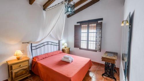 AlmácharCasa Lagar El Mirador Almachar by Ruralidays的一间卧室设有红色的床和窗户。