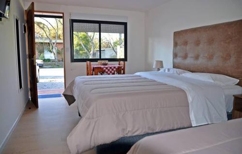 特立尼达岛Trinidad Inn Flores的酒店客房设有两张床和窗户。
