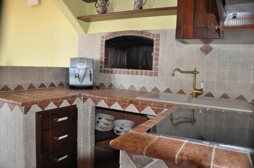 塔维亚诺Corte degli Aranci Casa Vacanze的厨房配有带水槽的柜台和柜台的四柱床