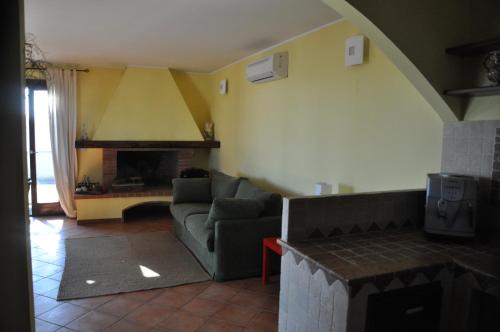 塔维亚诺Corte degli Aranci Casa Vacanze的带沙发和壁炉的客厅