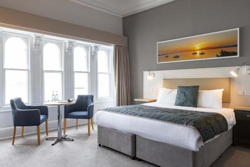 奥本西部大酒店的酒店客房带一张床、一张桌子和椅子