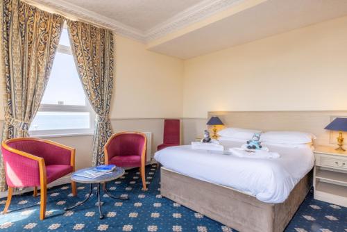布莱克浦The Caledonian Tower Hotel的酒店客房,配有一张床和两把椅子