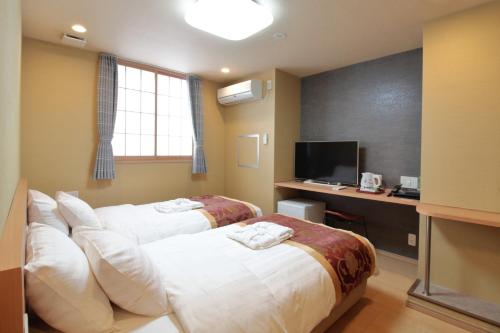 东京Arakawa-ku - Hotel / Vacation STAY 22248的酒店客房配有两张床和一张书桌