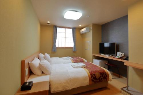 东京Arakawa-ku - Hotel / Vacation STAY 22248的一间卧室配有一张床、一张书桌和一台电视