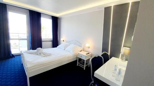 Pionki帝国酒店 的酒店客房设有一张床和两个窗户。