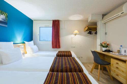 蒙吕松Comfort Hotel Montlucon的配有一张床和一张书桌的酒店客房