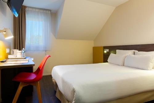 洛姆东里尔 - 洛姆基里亚德酒店的酒店客房,配有一张床和一张红色椅子