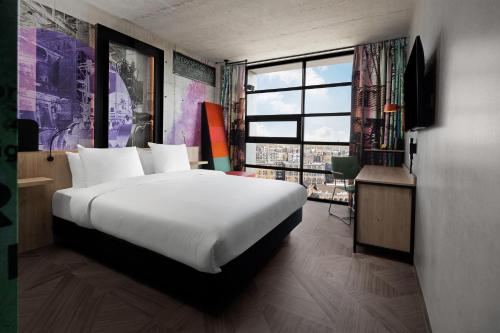 阿姆斯特丹Inntel Hotels Amsterdam Landmark的一间卧室设有一张大床和一个大窗户