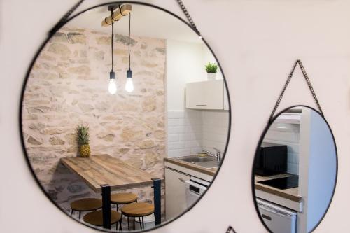 尼姆Appartement Cosy Nîmes-Centre的镜子反射着厨房,配有桌椅