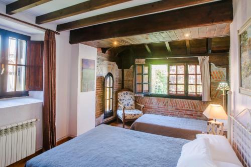 朗格勒朗格雷旅馆的一间卧室设有两张床、一把椅子和窗户。