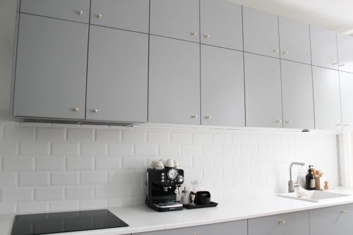 SpirkelbachApartment Rose的厨房配有白色橱柜和台面上的咖啡壶