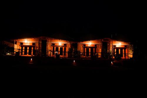 AkageraAkagera Transit Lodge的夜晚点亮的房屋,灯火在里面