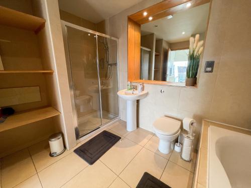 格拉斯哥City Centre 2-Bed Apartment Parking Jacuzzi Bath的带淋浴卫生间和盥洗盆的浴室
