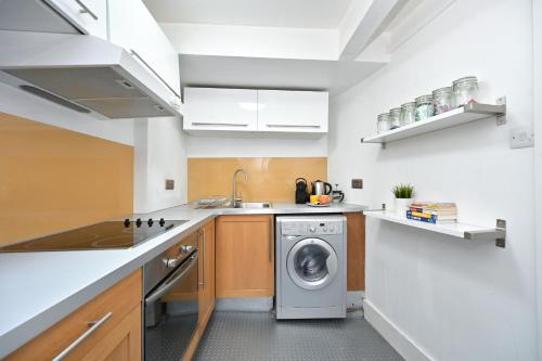 伦敦Soho, Piccadilly & Chinatown - Two Bedroom & Two Double Beds Apartment的厨房配有洗衣机和洗衣机。