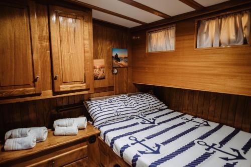 巴勒莫Sicily Sea Charter HANDE CAPO GALERA的木制客房内的一间卧室,配有一张床