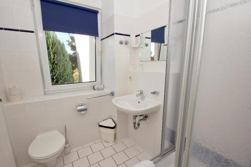 洛布F-1010 Strandhaus Mönchgut Bed&Breakfast DZ 28 Terrasse strandnah, inkl Frühstück的白色的浴室设有卫生间和水槽。