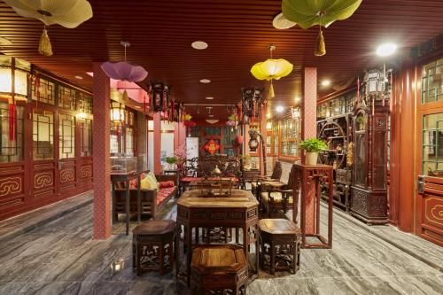 北京北京荣府老宅四合院精品酒店 的一间在房间内配有桌椅的餐厅