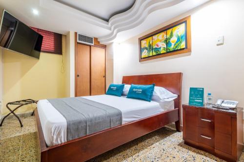布卡拉曼加Ayenda Almirante的一间卧室配有一张带蓝色枕头的床和一台电视。