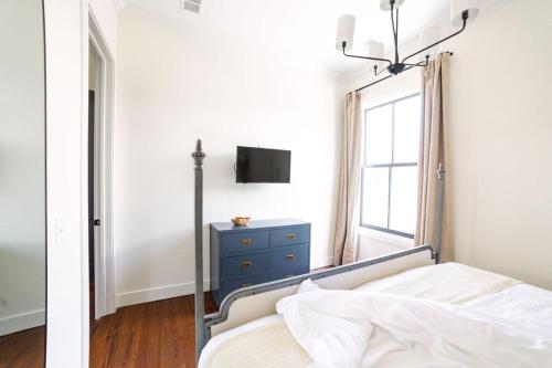 查尔斯顿Guesthouse Charleston EAST 46 G的一间卧室配有一张带蓝色梳妆台和窗户的床。