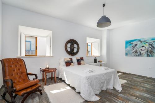 埃斯坦巴Casa Celeiro的白色的客房配有一张床和椅子