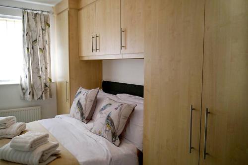 布莱克浦Bee Bungalow in Blackpool的卧室内的一张带白色床单和枕头的床
