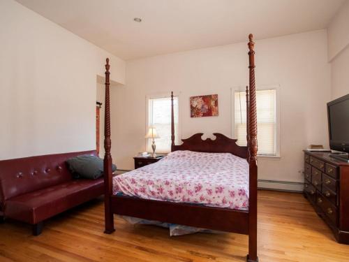 剑桥温莎旅馆的一间卧室配有天蓬床和沙发