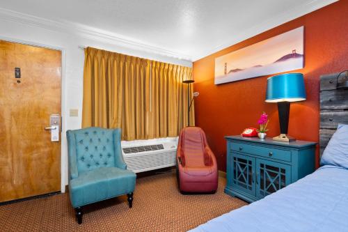 南旧金山阿美莉卡那汽车旅馆的酒店的客房 - 带一张床、椅子和窗户